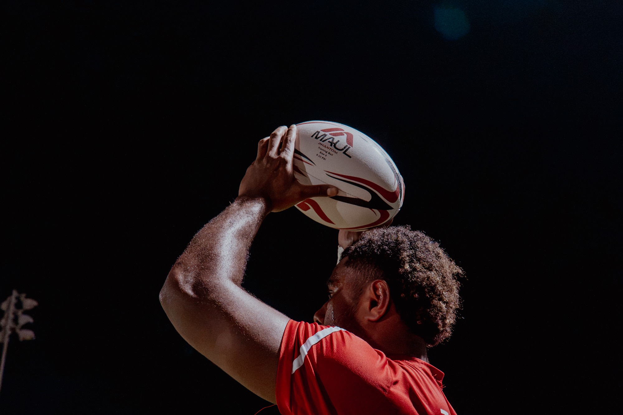 Player raising a MAUL Phantom ball overhead, logo centered